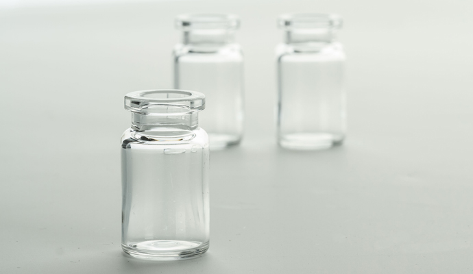 Plastic COP vials with low protein adsorption